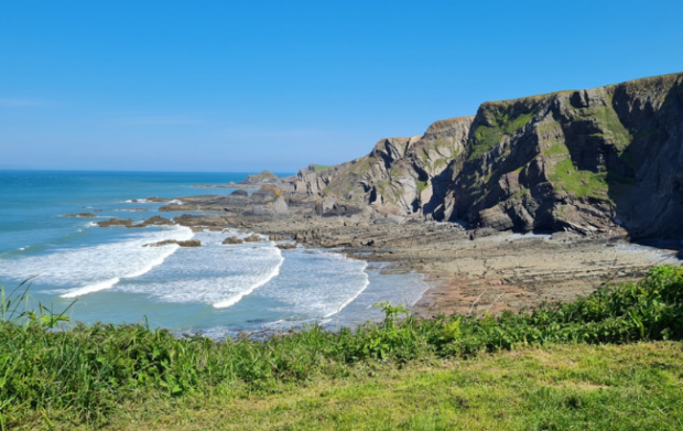 picture of Hartland Quay, sunny coastland with waves lapping into the quay