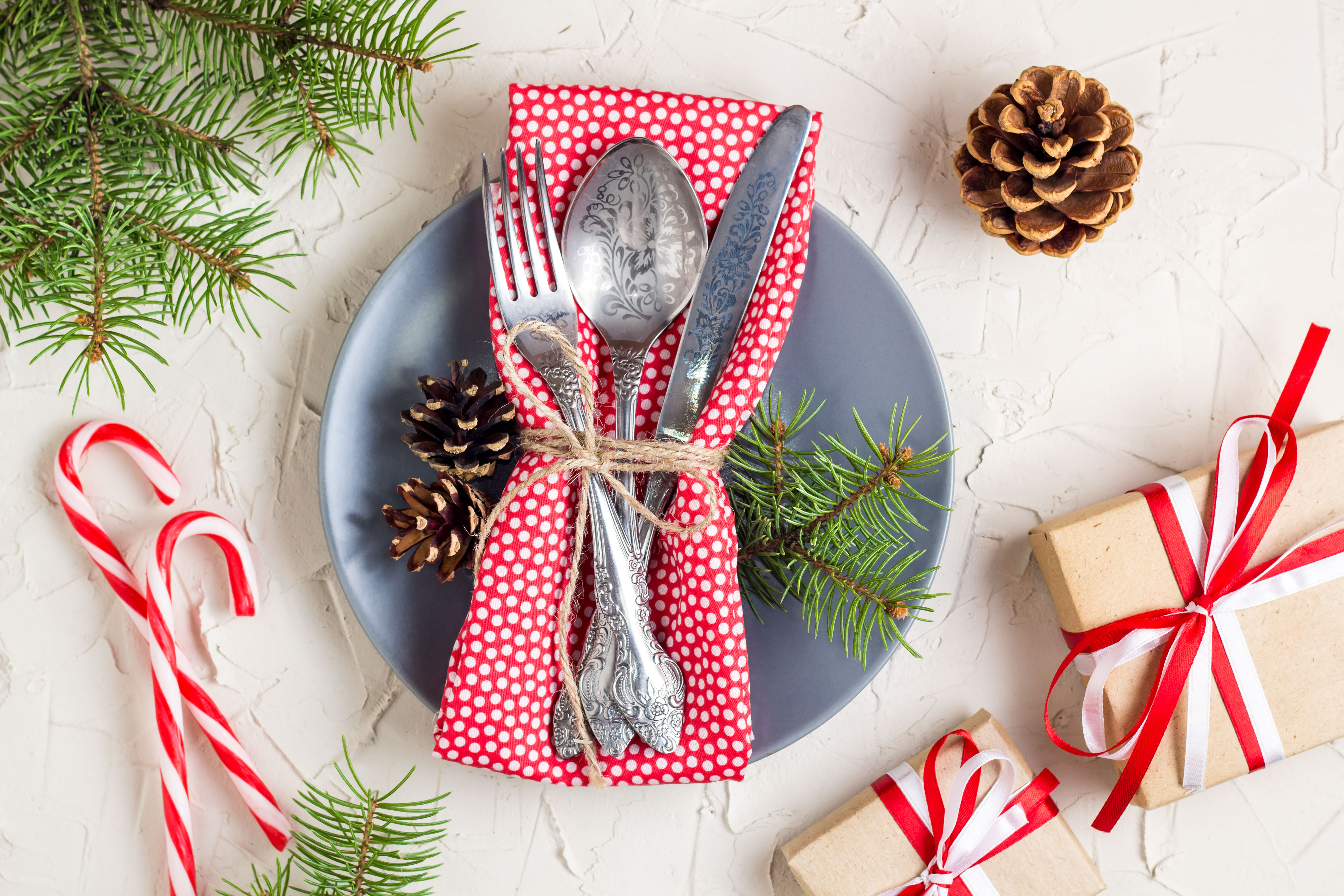 image of christmas decorations including a place with knife and forks, surrounded by candy canes and presents.