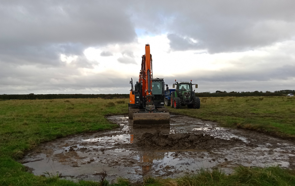 Image of tractor creating ghost pond by digging up mud